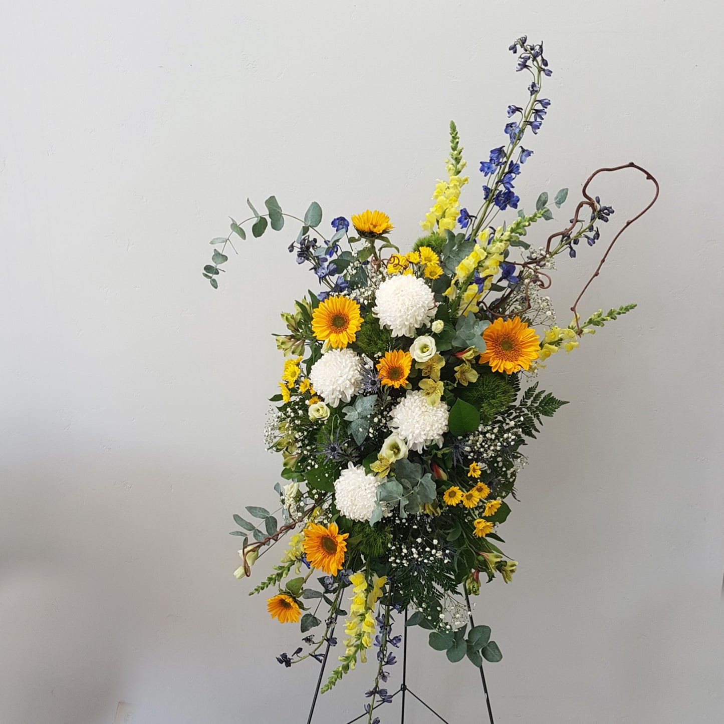 casket spray oleander floral design toronto same day flower delivery sympathy funeral etobicoke yellow white and blue flowers sunflowers delphinium snapdragons eucalyptus