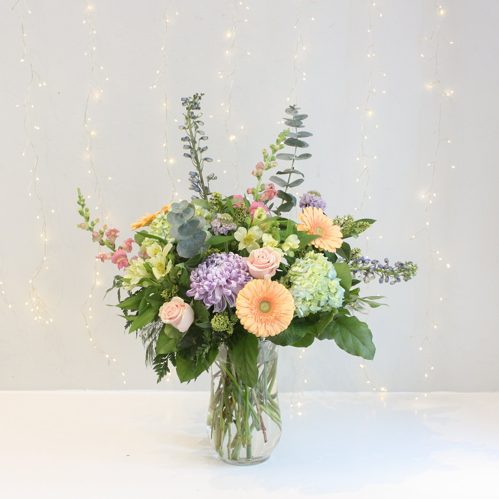 pastel coloured floral arrangement with mix of gerbera daisies hydrangea roses eucalyptus. Designed at oleander floral design in toronto offering same day delivery