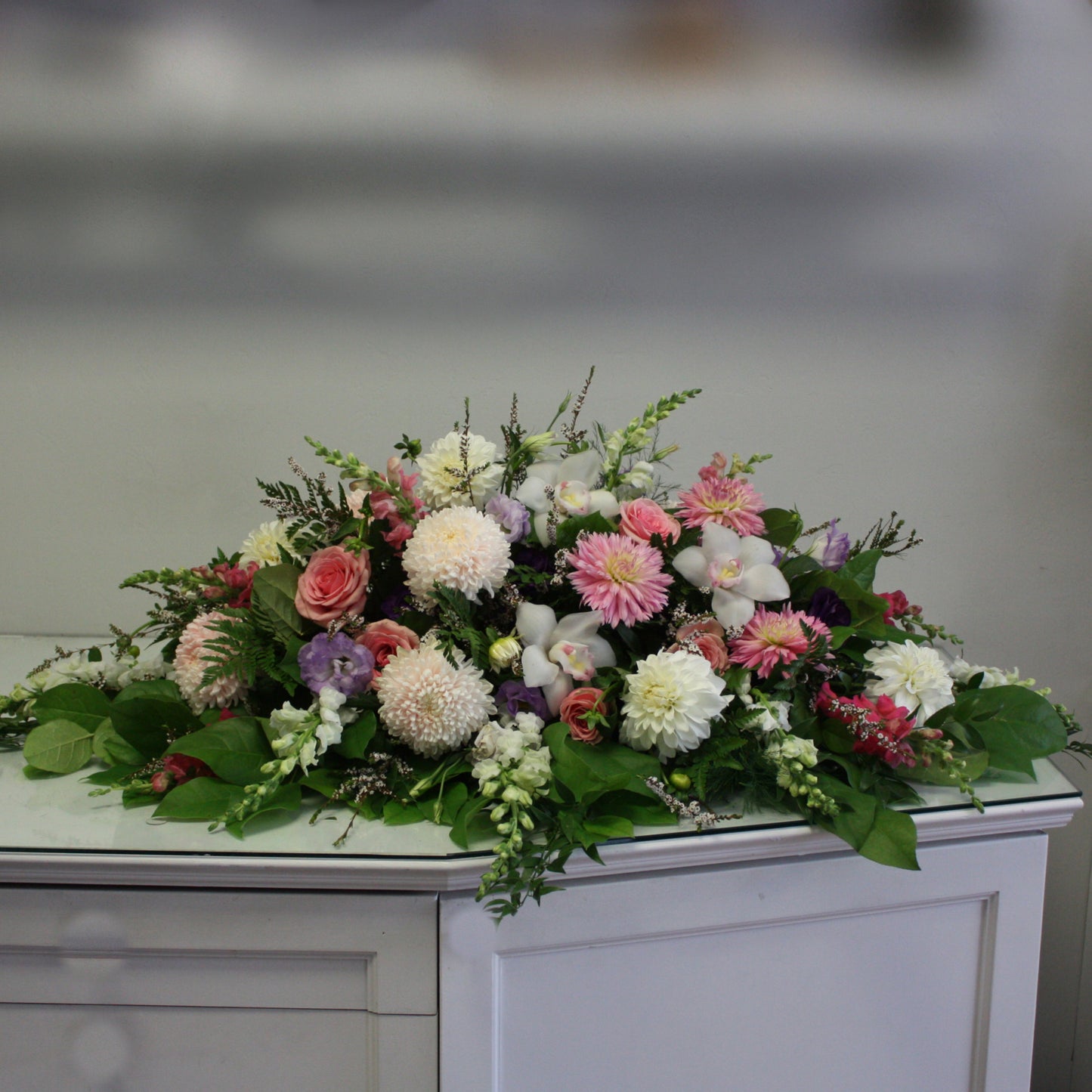 casket spray oleander floral design toronto same day flower delivery sympathy funeral etobicoke white and green flowers orchid rose eucalyptus dahlia delphinium snapdragons